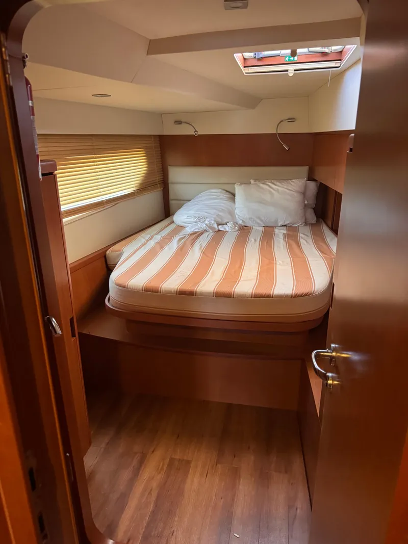 Slide: The Image of Cozy cabin interior of 2018 Aquila 48 yacht with striped bedding and wooden finishes. - 37
