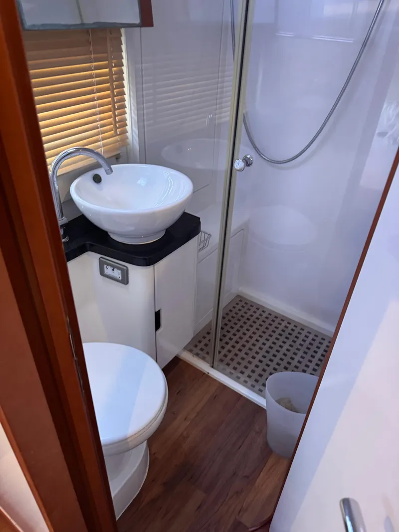 Slide: The Image of Compact bathroom in 2018 Aquila 48 yacht with shower, sink, and toilet. - 39