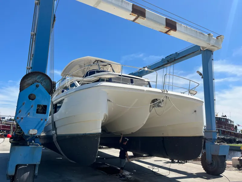 Slide: The Image of Aquila 48 catamaran from 2018 being lifted by a boat hoist. - 4