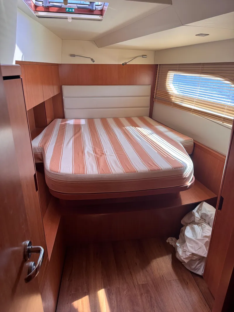 Slide: The Image of Cabin interior of 2018 Aquila 48 yacht with striped mattress and wooden finish. - 40