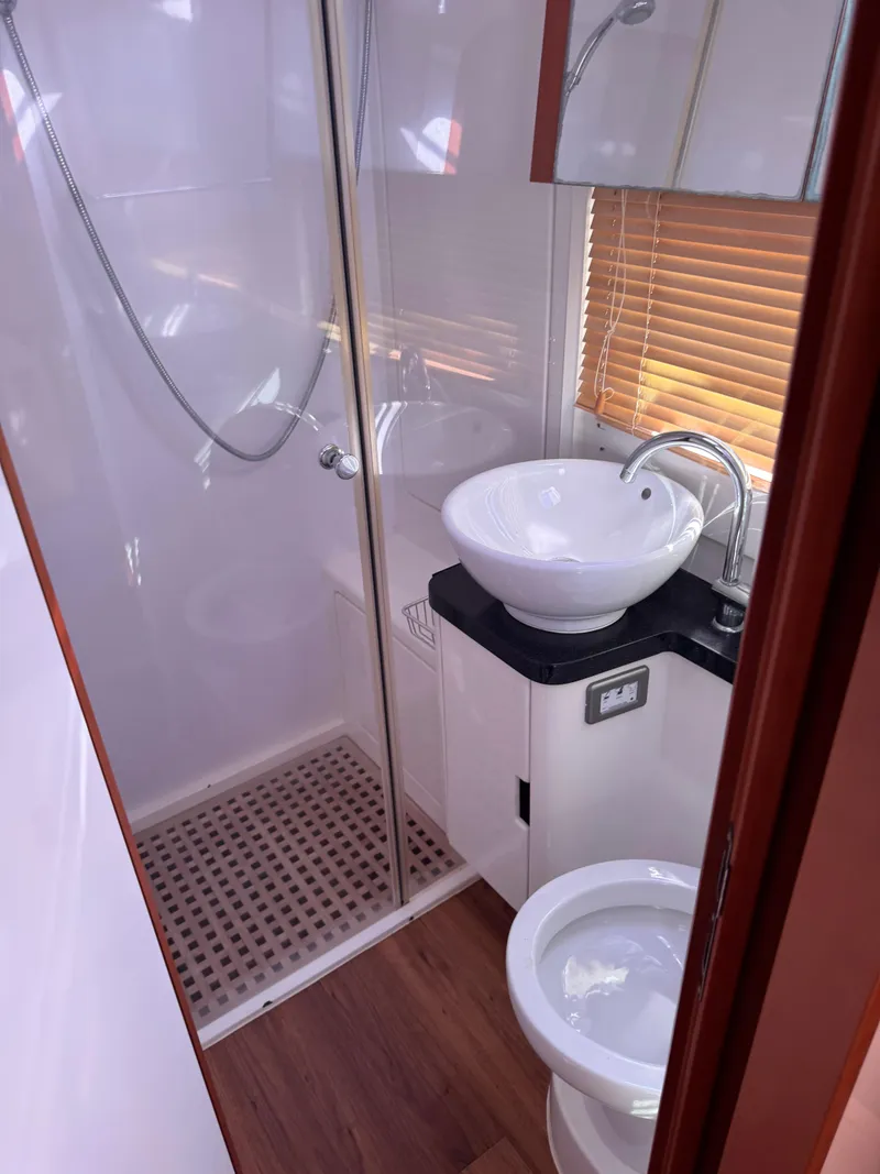 Slide: The Image of Compact bathroom in 2018 Aquila 48 yacht with shower, sink, and toilet. - 43
