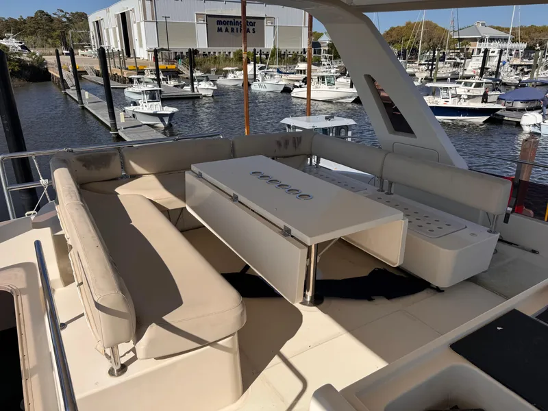 Slide: The Image of Spacious seating area on 2018 Aquila 48 yacht at marina, featuring a central table. - 46