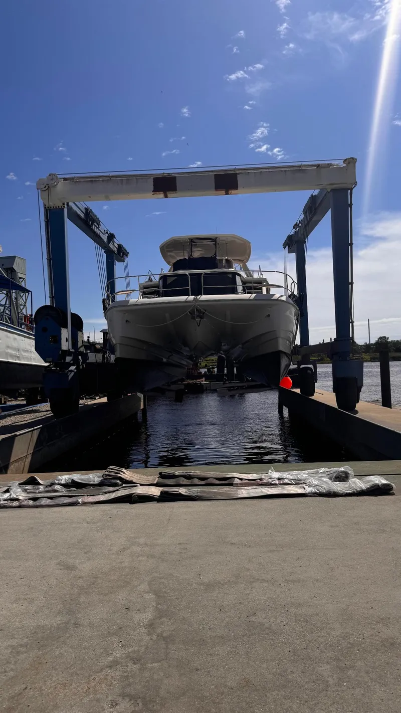 Slide: The Image of Aquila 48 yacht in dry dock, 2018 model, under a blue sky. - 8