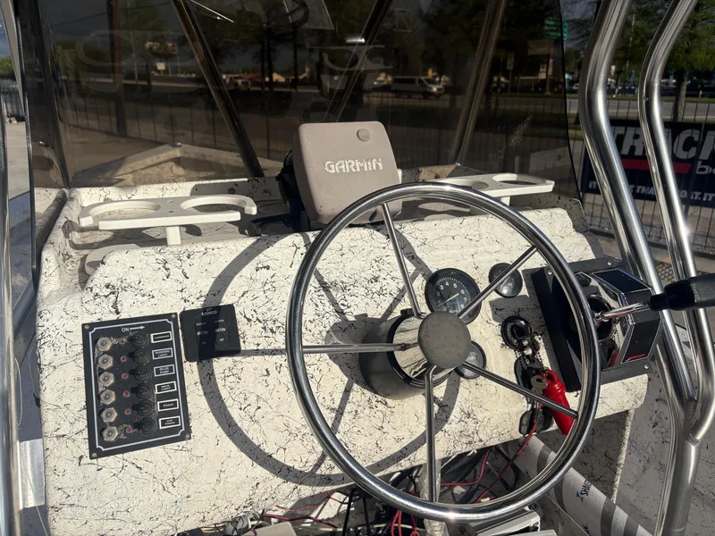 Slide: The Image of Console of a 2000 Skiff Reno 23 boat with steering wheel and Garmin device. - 11