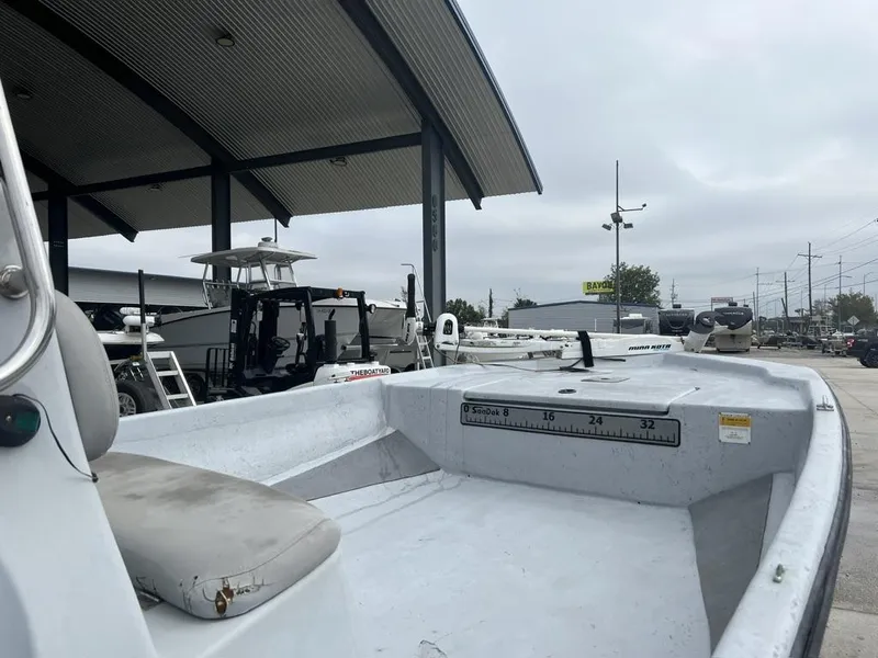 Slide: The Image of 2014 Blue Wave 2200 boat at a dealership, featuring spacious deck and seating. - 10