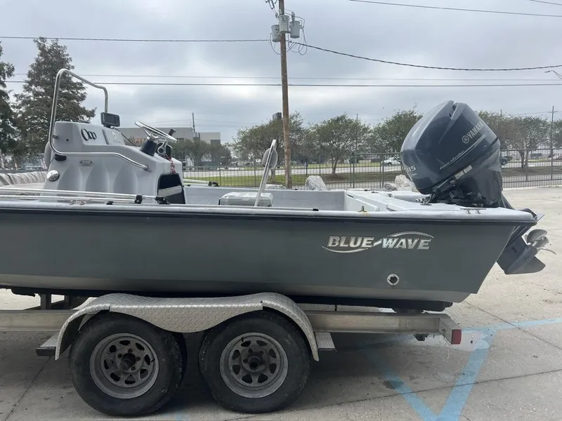 Slide: The Image of 2014 Blue Wave 2200 boat on trailer with Yamaha outboard motor, parked outdoors. - 15
