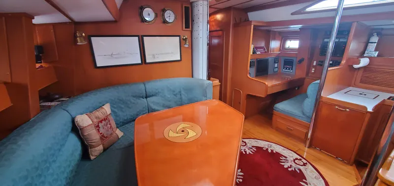 Slide: The Image of Luxurious 1989 Tayana 55 yacht interior with elegant wood finish and cozy seating area. - 16