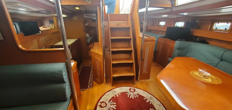 Slide: The Image of Interior of 1989 Tayana 55 yacht with wooden finishes and cozy seating area. - 19
