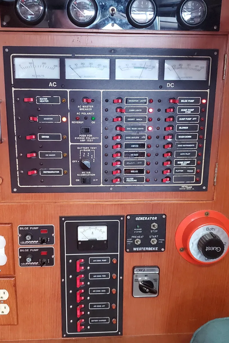 Slide: The Image of Electrical control panel on a 1989 Tayana 55 yacht, featuring AC and DC meters. - 21