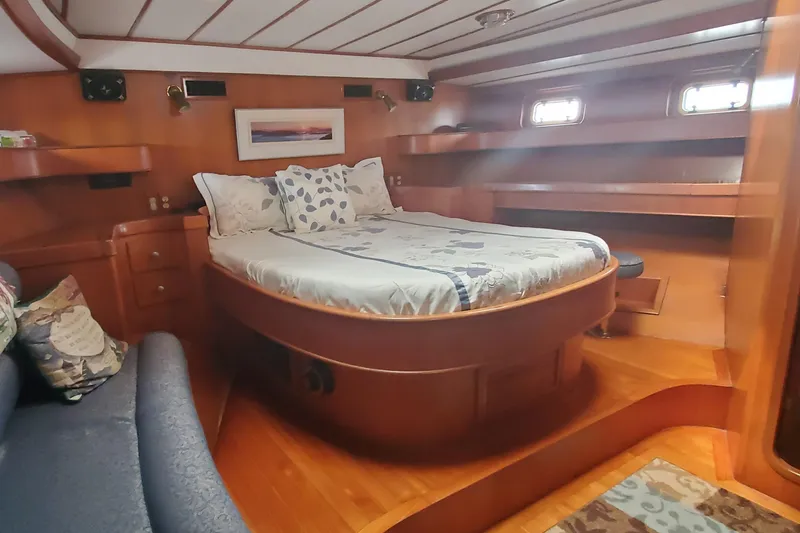 Slide: The Image of Luxurious 1989 Tayana 55 yacht cabin with wooden interior and cozy bed. - 26