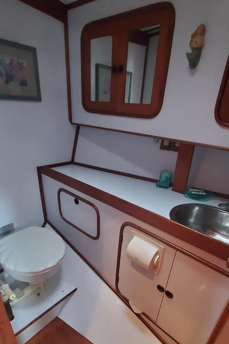 Slide: The Image of 1989 Tayana 55 yacht bathroom with wooden accents and compact design. - 28