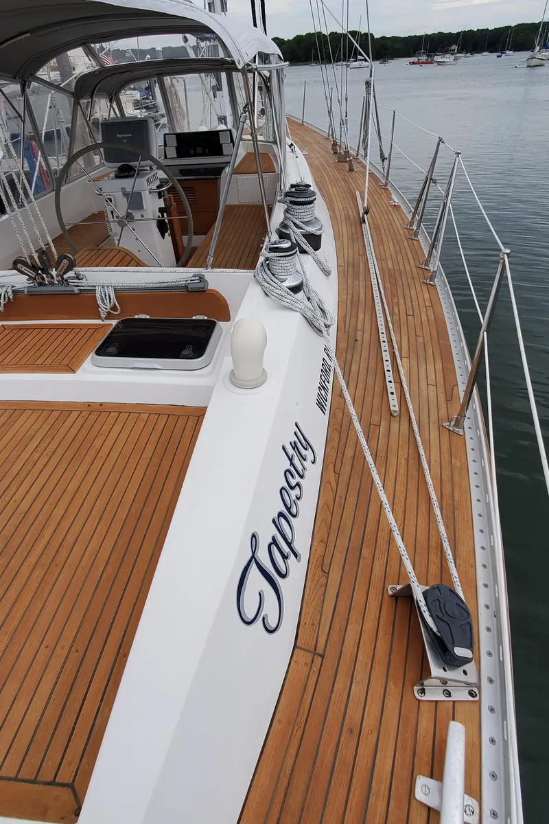 Slide: The Image of 1989 Tayana 55 sailboat with teak deck, docked in a marina. - 37