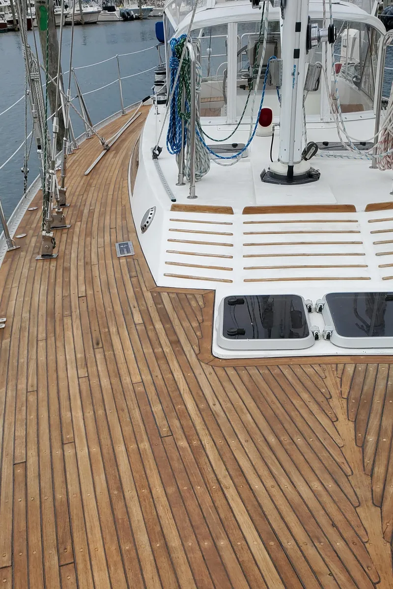 Slide: The Image of 1989 Tayana 55 sailboat deck with teak wood finish and rigging details. - 38