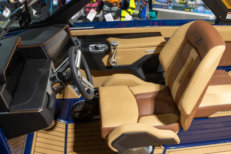Slide: The Image of 2025 MasterCraft X24 interior with tan and brown seating, modern dashboard, and steering wheel. - 4
