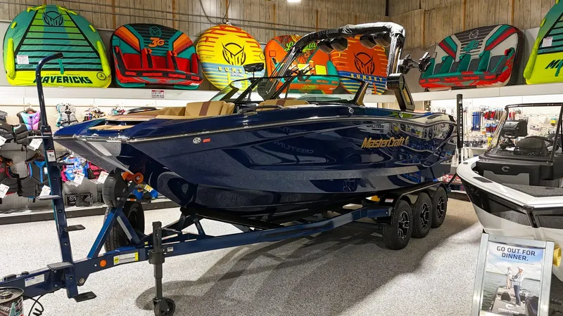 Slide: The Image of 2025 MasterCraft X24 boat displayed in a showroom with colorful water sports gear. - 7