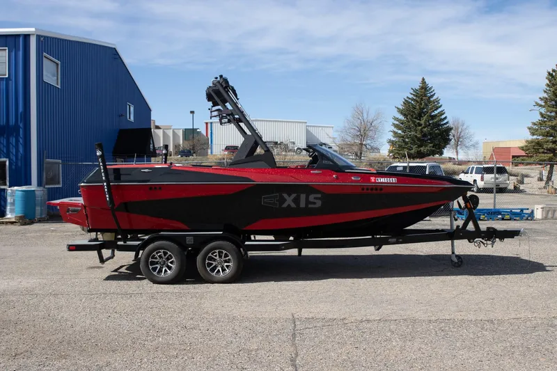 Slide: The Image of 2022 Axis A20 boat in red and black on a trailer, parked outdoors. - 1