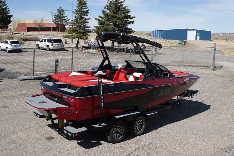 Slide: The Image of 2022 Axis A20 boat with red and black design on a trailer in a parking lot. - 2
