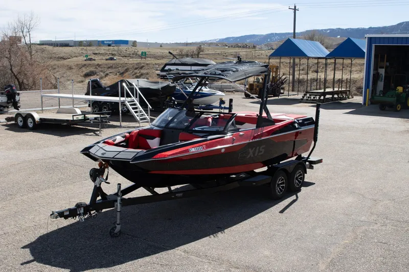 Slide: The Image of 2022 Axis A20 boat on trailer in outdoor lot, surrounded by other boats and equipment. - 3