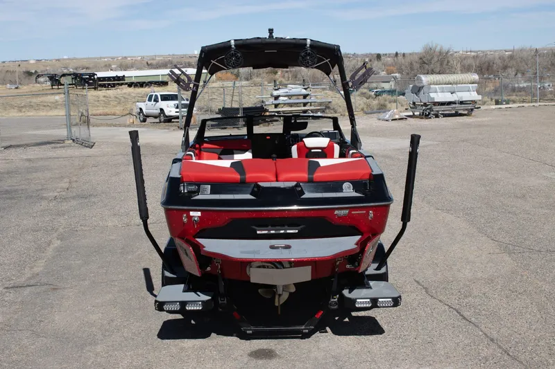 Slide: The Image of 2022 Axis A20 boat with red and black seating, parked outdoors. - 4