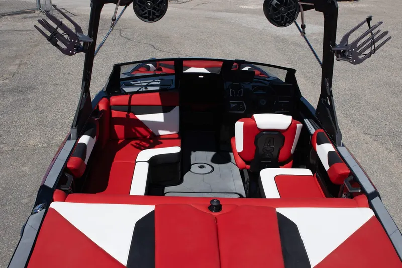 Slide: The Image of 2022 Axis A20 boat interior with red and white seating, featuring wakeboard racks and speakers. - 7