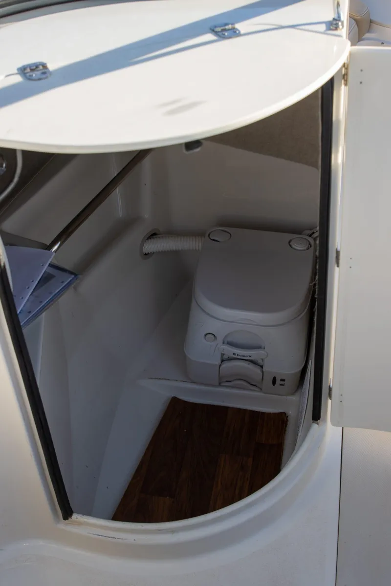 Slide: The Image of 2016 Stingray 215LR Sport Deck boat interior with compact marine toilet. - 10