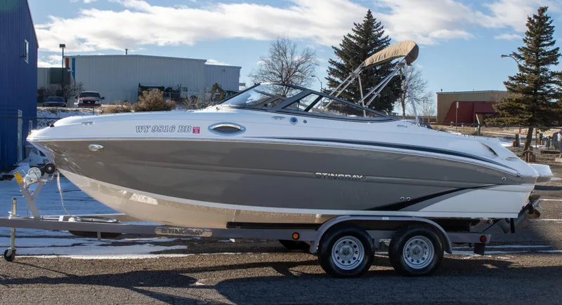 Slide: The Image of 2016 Stingray 215LR Sport Deck boat on trailer, parked outdoors. - 3