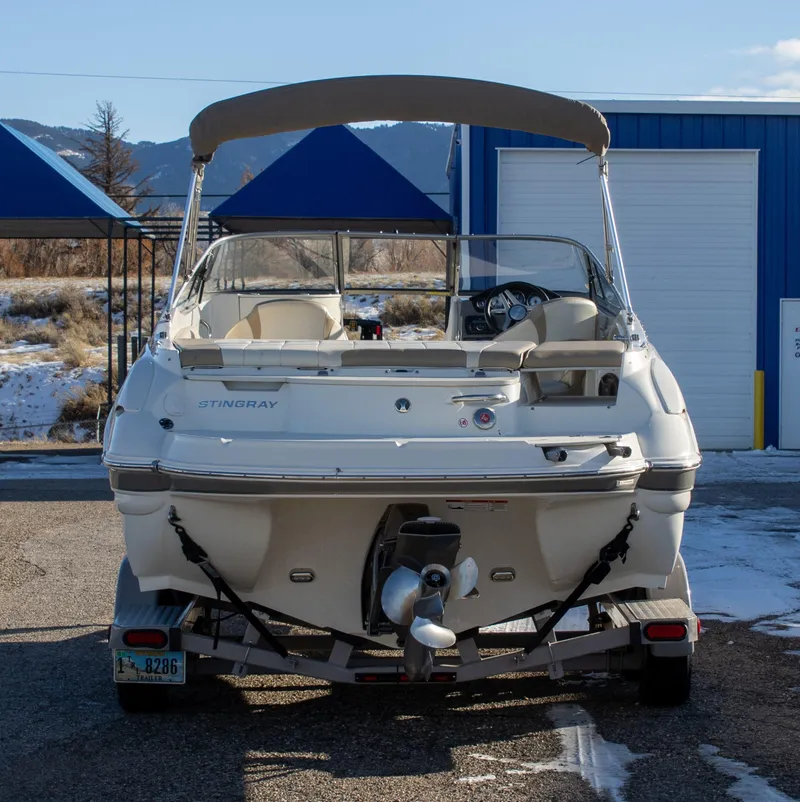 Slide: The Image of 2016 Stingray 215LR Sport Deck boat on trailer, parked outdoors with mountains in background. - 4