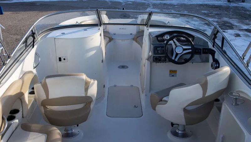 Slide: The Image of 2016 Stingray 215LR Sport Deck boat interior with steering wheel and seating. - 6