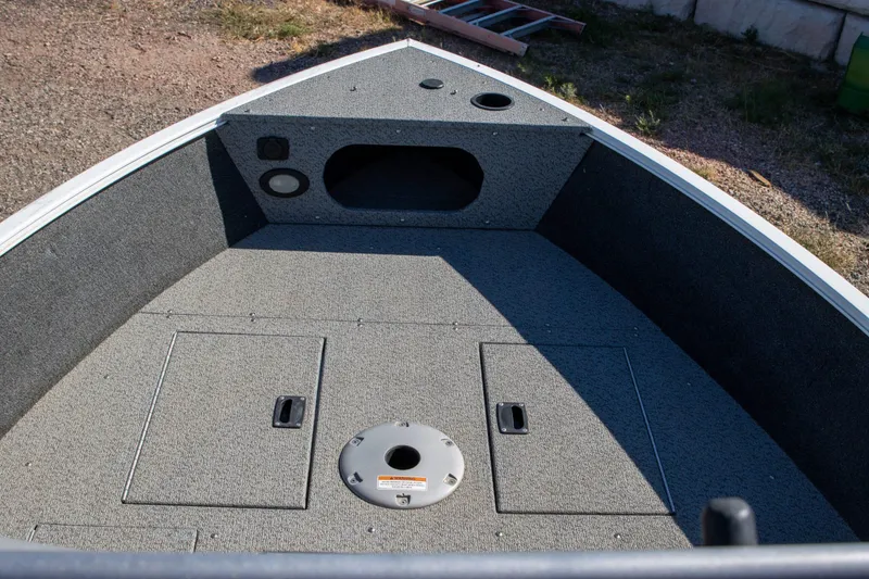 Slide: The Image of 2023 Crestliner 1600 Vision boat interior with storage compartments and carpeted deck. - 6