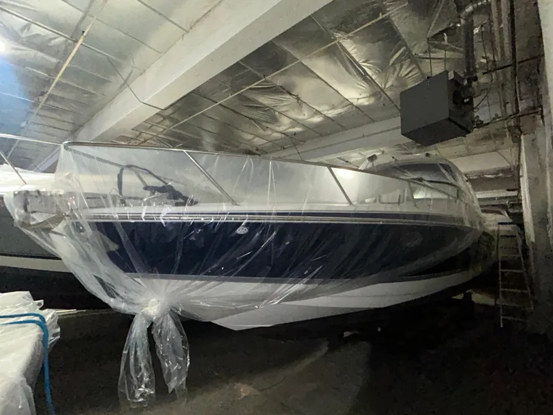 Slide: The Image of 2007 Formula 330 SS boat covered in plastic, stored indoors. - 2