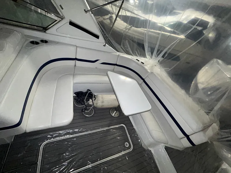 Slide: The Image of 2007 Formula 330 SS boat interior with white seating and table, covered in protective plastic. - 7