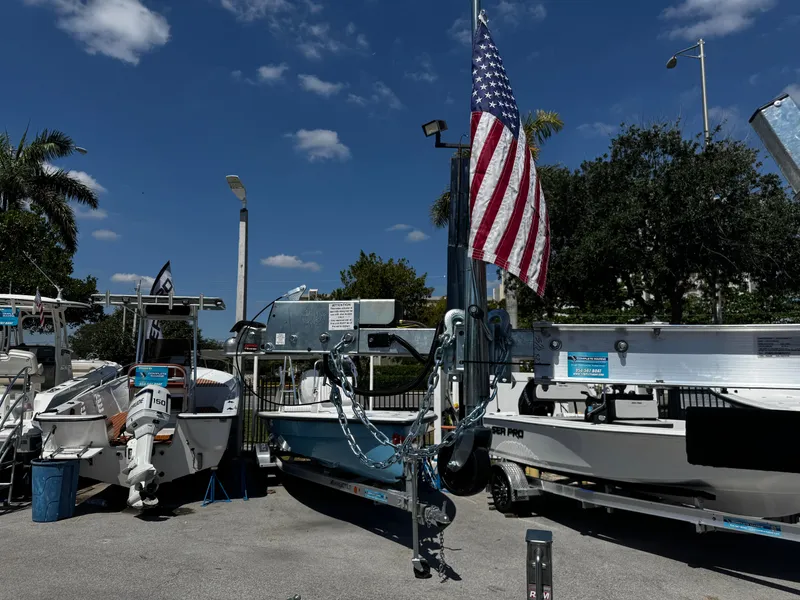 Slide: The Image of Boat trailers and boats displayed outdoors under a clear sky, featuring an American flag. - 12