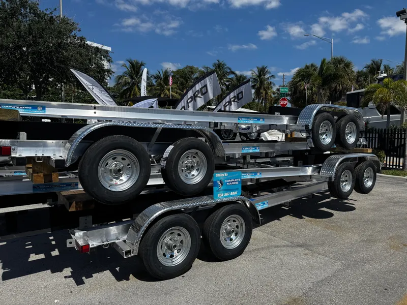 Slide: The Image of 2025 Trailer 17-30 model, stacked, with dual axles, parked outdoors under a clear sky. - 2