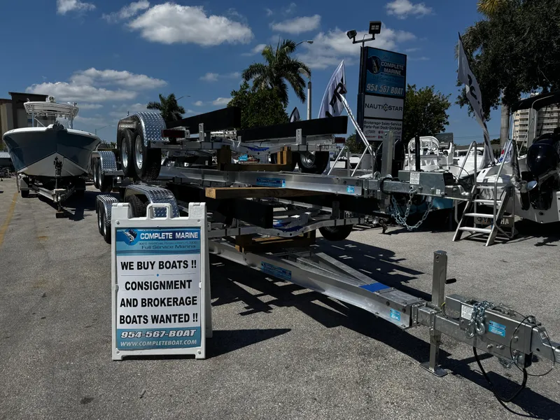 Slide: The Image of Boat trailers on display with a sign for consignment and brokerage services. - 9