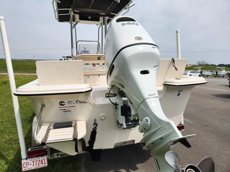 Slide: The Image of 2023 Carolina Skiff 21 LS boat with outboard motor, parked on a trailer. - 3