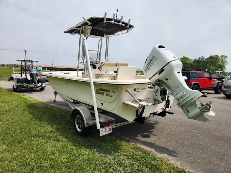 Slide: The Image of 2023 Carolina Skiff 21 LS boat on trailer, parked outdoors with outboard motor. - 4