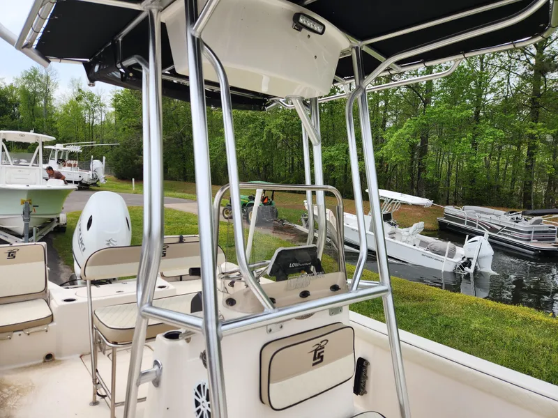 Slide: The Image of 2023 Carolina Skiff 21 LS boat docked near a scenic lakeside with other boats. - 9