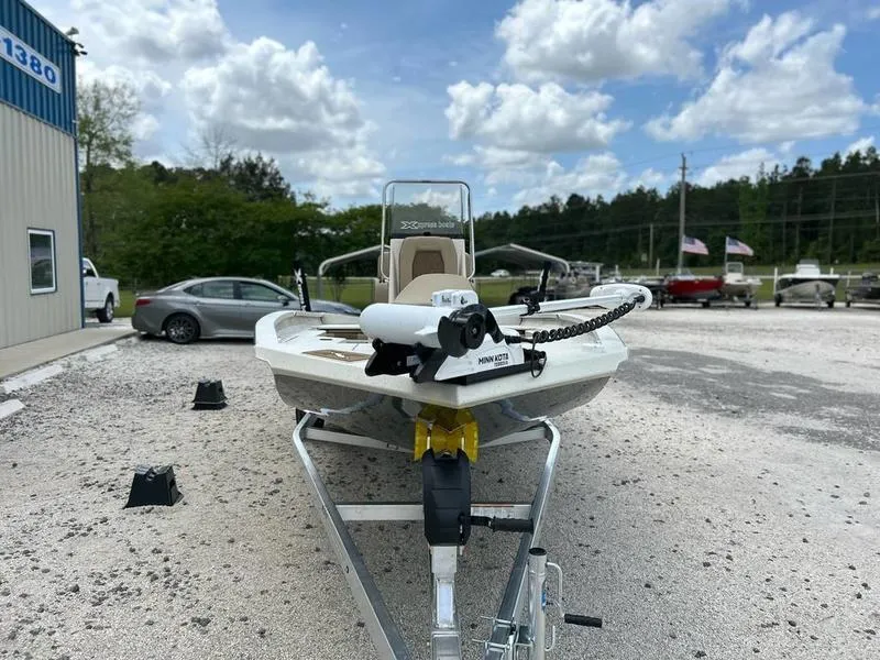 Slide: The Image of 2025 Xpress H20 BAY boat on trailer, parked outdoors under a cloudy sky. - 2