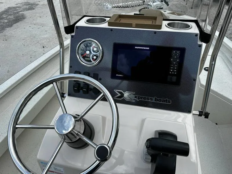 Slide: The Image of 2025 Xpress H20 BAY boat dashboard with steering wheel and navigation display. - 4