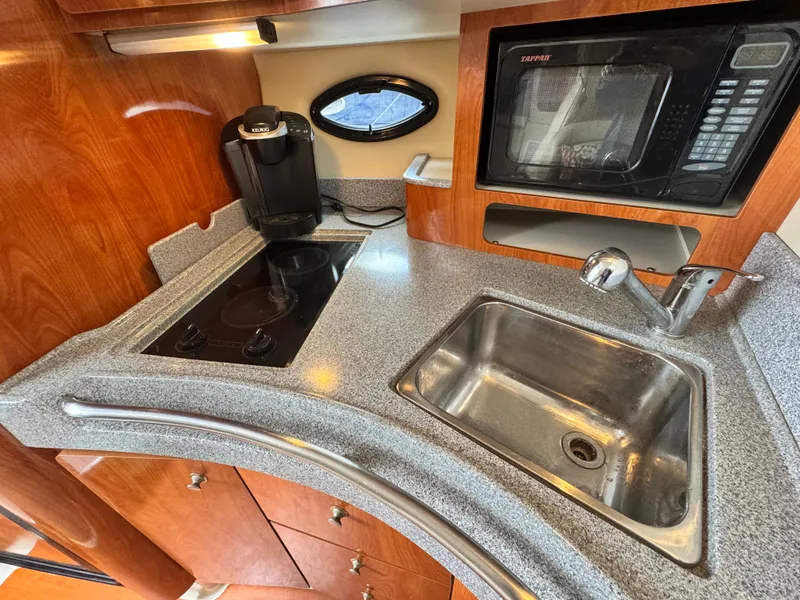 Slide: The Image of 2005 Larson 370 Cabrio yacht kitchen with sink, stove, microwave, and coffee maker. - 20