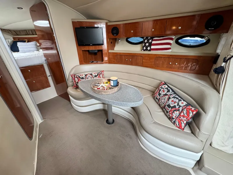 Slide: The Image of 2005 Larson 370 Cabrio interior with curved seating, TV, and nautical decor. - 21
