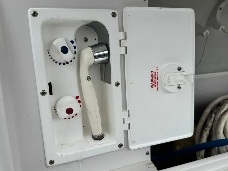Slide: The Image of 2005 Larson 370 CABRIO boat shower controls with open compartment and hose. - 26