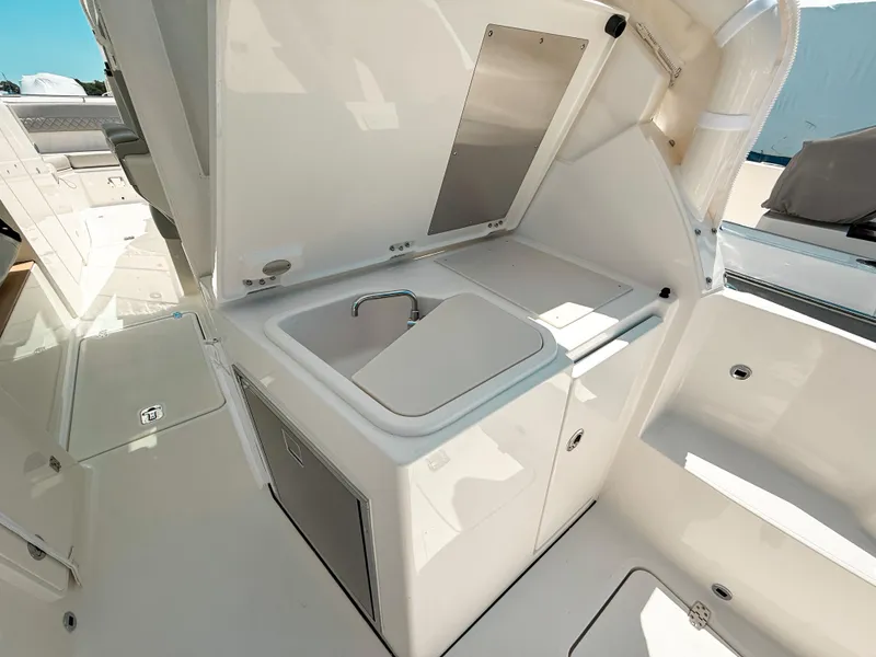 Slide: The Image of 2025 Pursuit DC 326 Dual Console boat interior with sink and storage area. - 14