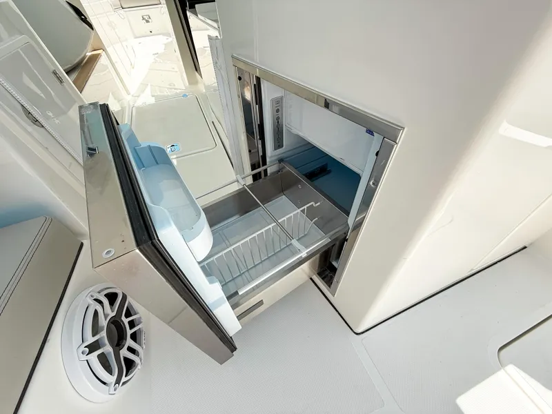 Slide: The Image of Open storage compartment on 2025 Pursuit DC 326 Dual Console boat. - 15