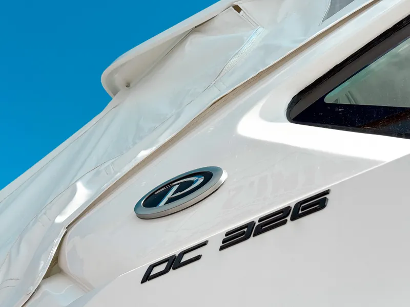 Slide: The Image of 2025 Pursuit DC 326 Dual Console boat, close-up view with logo and model name. - 2