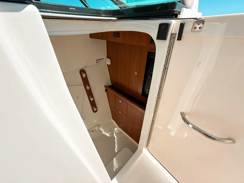 Slide: The Image of 2025 Pursuit DC 326 Dual Console interior cabin with wooden cabinetry and sleek design. - 24