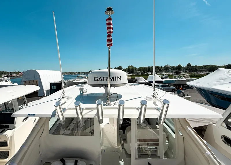 Slide: The Image of 2025 Pursuit DC 326 Dual Console boat with Garmin equipment, docked under clear blue sky. - 29