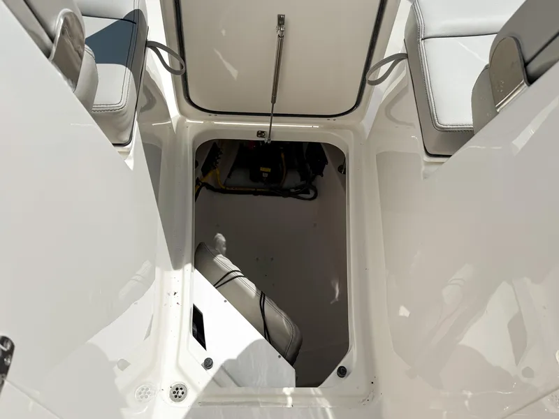 Slide: The Image of 2025 Pursuit DC 326 Dual Console boat storage compartment, open hatch view. - 30