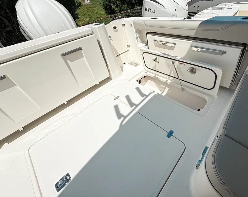 Slide: The Image of 2025 Pursuit DC 326 Dual Console boat interior with storage compartments and seating area. - 33