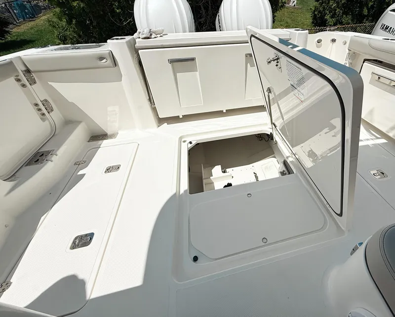 Slide: The Image of 2025 Pursuit DC 326 Dual Console boat with open storage compartments on deck. - 34